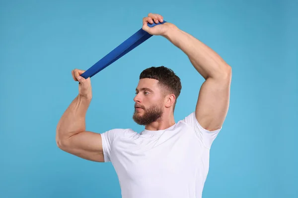 Young Man Exercising Elastic Resistance Band Light Blue Background — Stock Photo, Image