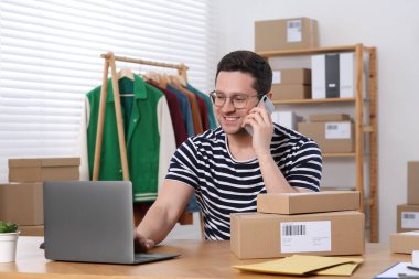 Seller talking on phone while working in office. Online store