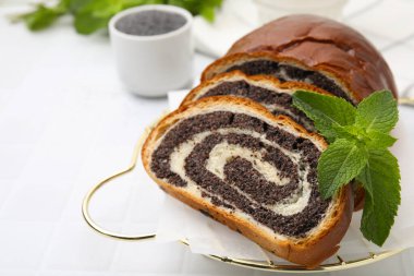 Haşhaş tohumu dilimleri ve beyaz fayanslı masada nane şekeri, yazı için yeri olan yakın plan. Pasta nefis.