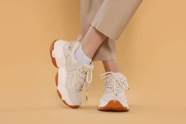 Wanita Mengenakan Sepasang Sepatu Baru Bergaya Sepatu Latar Beige Closeup — Stok Foto