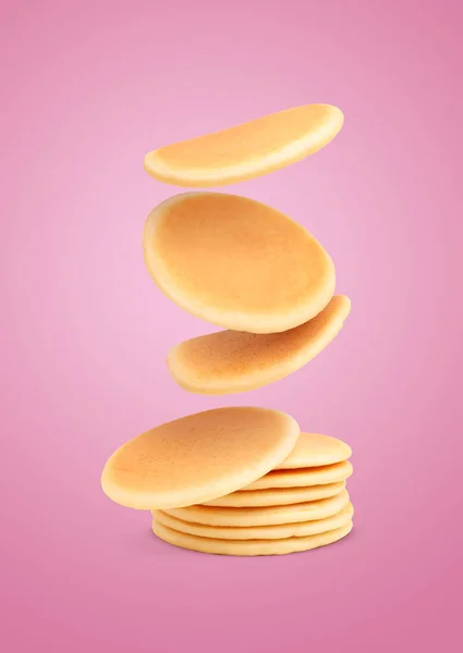 Many Fresh Pancakes Falling Pink Background — Stock Photo, Image