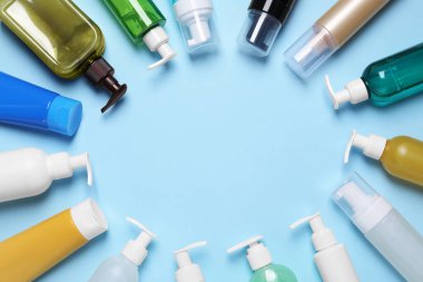 Açık mavi arkaplandaki farklı temizleyicilerden yapılmış çerçeve, metin için yeri olan düz bir çerçeve. Kozmetik ürünü