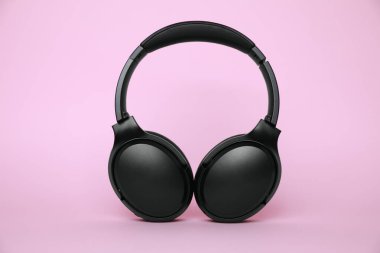 Pembe arka planda modern siyah kablosuz kulaklık.