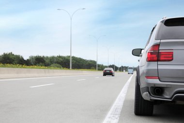 Gri modern araba asfalt yolda park edilmiş.