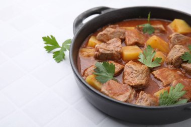 Beyaz fayanslı masada, tencerede leziz gulaş, yakın plan. Metin için boşluk