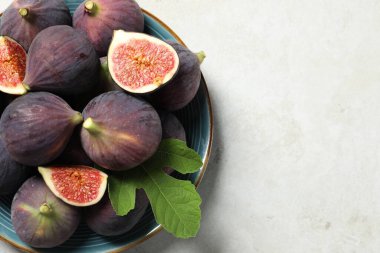 Üstünde taze incir ve yeşil yaprak olan bir tabak. Metin için boşluk