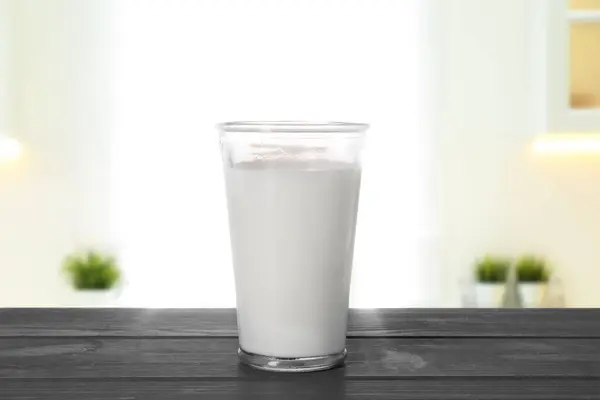 部屋の木のテーブルのガラスで新鮮なミルク — ストック写真