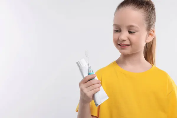 Ευτυχισμένο Κορίτσι Που Κρατάει Ηλεκτρική Οδοντόβουρτσα Και Οδοντόπαστα Λευκό Φόντο — Φωτογραφία Αρχείου