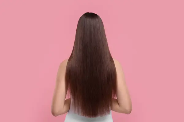 ピンクの背景の処置の後の滑らかな健康な毛の女性 背部眺め — ストック写真