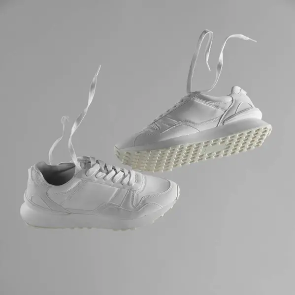 一双浅灰色背景的时髦白色运动鞋 案文的篇幅 — 图库照片