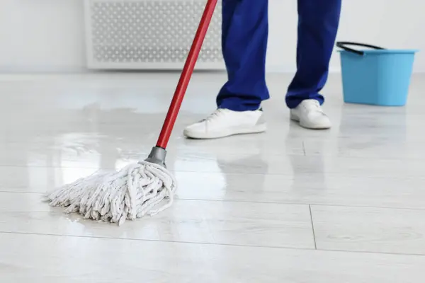 Man cleaning floor with mop indoors, closeup