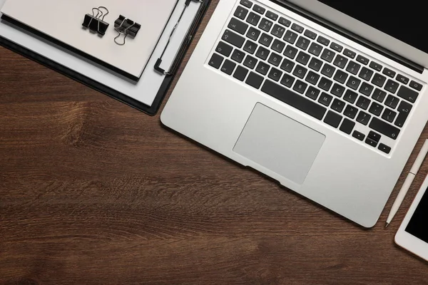 Diz üstü bilgisayar ve ahşap masadaki farklı kırtasiye malzemeleri, metin için yeri olan düz bir yer. Merkez Ofis