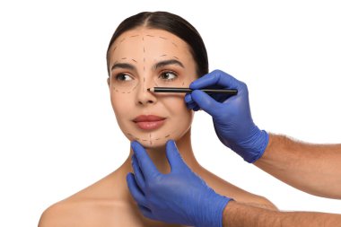 Beyaz arka planda estetik ameliyat için kalem hazırlayan bir doktor.
