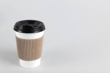 Arka planda plastik kapaklı kağıt bardak, metin için boşluk. Kahve hazır.