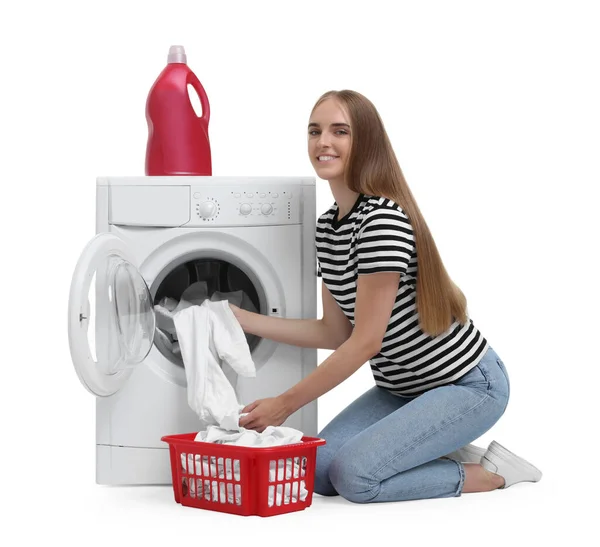 白い背景の洗濯機から洗濯物を取る美しい若い女性 — ストック写真