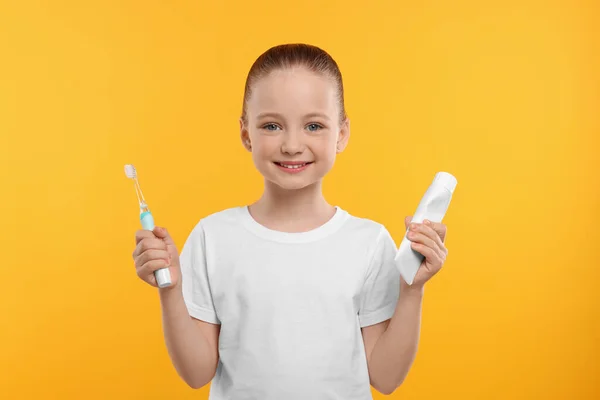 Щаслива Дівчина Тримає Електричну Зубну Щітку Трубку Зубної Пасти Жовтому — стокове фото