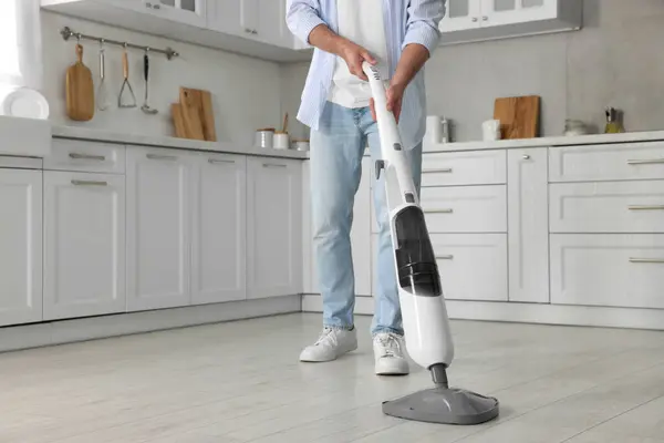 自宅でキッチンでスチームモップで床を掃除する男 クローズアップ — ストック写真