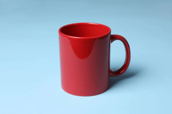 浅蓝色底色的红色陶瓷杯 — 图库照片