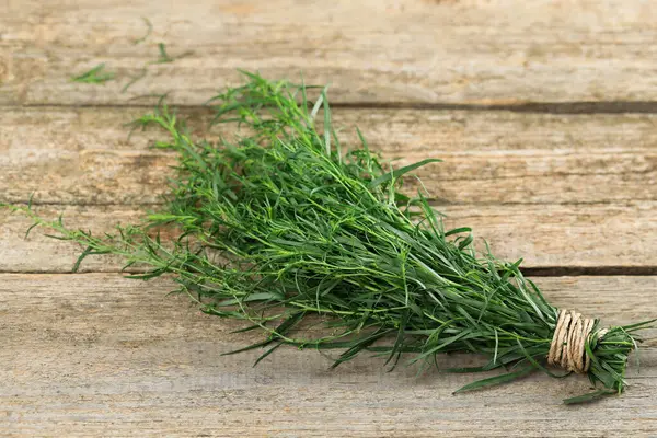 Bunch of fresh tarragon on wooden table