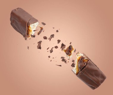 Kırık çikolata ve nefis karamel soluk kahverengi arka planda.