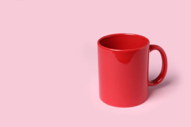 Pembe arkaplanda kırmızı seramik bardak, metin için boşluk