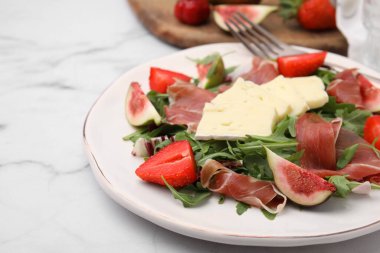 Peynirli lezzetli salata, prosciutto, çilek ve incirli beyaz mermer masa, yakın çekim. Metin için boşluk