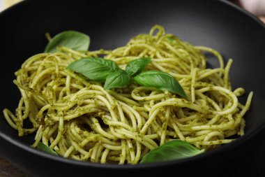 Pesto soslu lezzetli makarna ve kasede fesleğen, yakın plan.