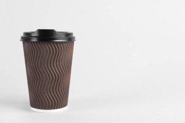 Açık arka planda plastik kapaklı kahverengi kağıt bardak, metin için boşluk. Kahve hazır.