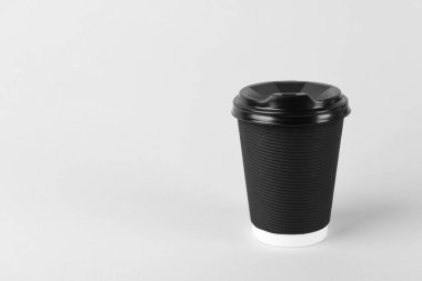 Arka planda plastik kapaklı siyah kağıt bardak, metin için boşluk. Kahve hazır.