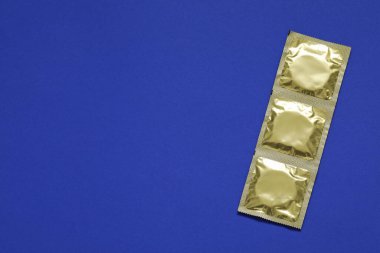 Açık mavi arkaplan üzerine kondom paketleri, üst görünüm ve metin için boşluk. Güvenli seks.