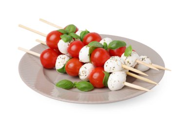 Beyaz domatesli Caprese şişleri, mozarella topları, fesleğen ve baharatlar.