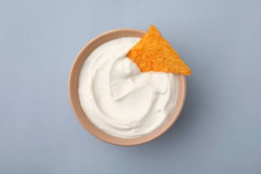 Gri arka planda kasede cipsle servis edilen lezzetli tofu sosu.