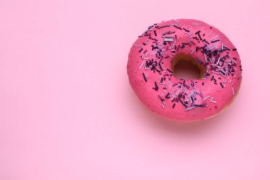 Pembe arka plan üzerine serpiştirilmiş jöleli donut, üst manzara. Mesaj için yer var. Lezzetli şekerlemeler.