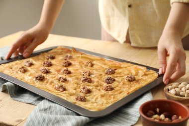 Ahşap masada nefis baklava pişiren kadın, yakın plan.