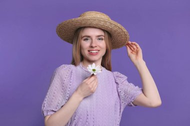 Mor arka planda elinde bahar çiçeğiyle güzel bir kadın