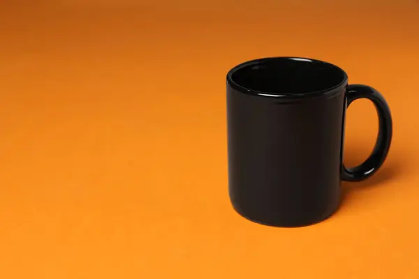 Μία Μαύρη Κεραμική Κούπα Πορτοκαλί Φόντο Χώρος Για Κείμενο — Φωτογραφία Αρχείου