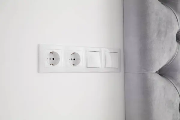 屋内ホワイトウォールのライトスイッチと電源ソケット — ストック写真