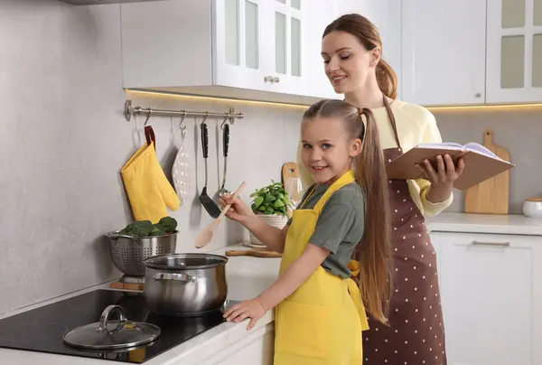 Schattig Klein Meisje Met Haar Moeder Koken Door Recept Boek — Stockfoto