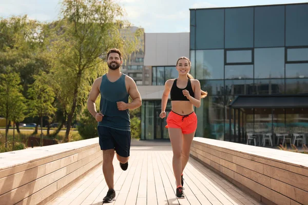 Healthy lifestyle. Happy couple running outdoors on sunny day