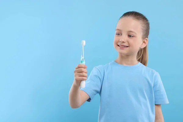 Щаслива Дівчина Тримає Електричну Зубну Щітку Світло Блакитному Тлі Простір — стокове фото