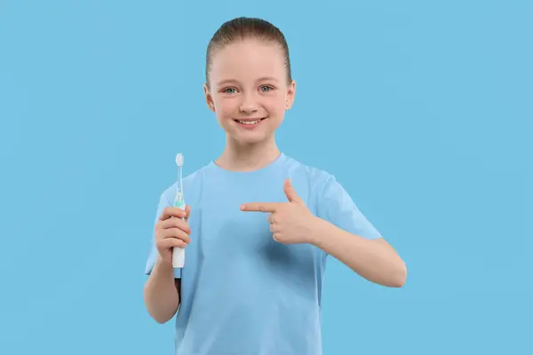 Щаслива Дівчина Тримає Електричну Зубну Щітку Світло Блакитному Фоні — стокове фото