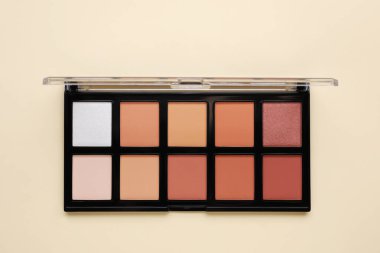 Bej arka planda rengarenk bir palet, üst manzara. Profesyonel kozmetik ürünü