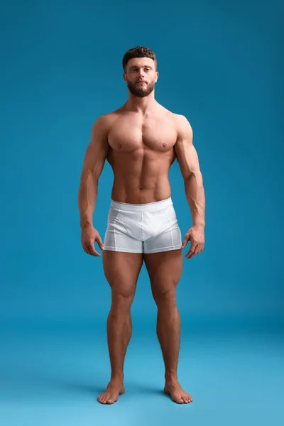 浅蓝色背景的英俊肌肉男子 性感的身体 — 图库照片