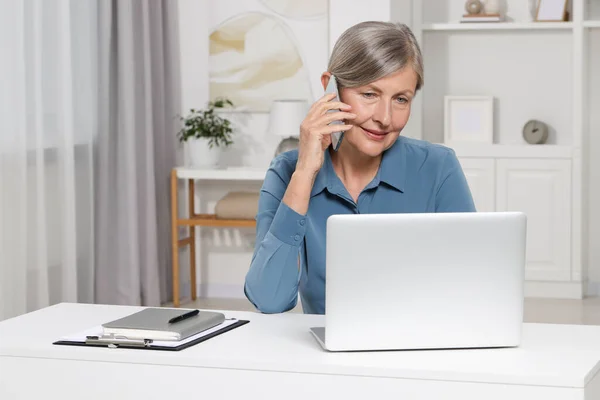 Beautiful Senior Woman Talking Phone While Using Laptop White Table — Stock Photo, Image