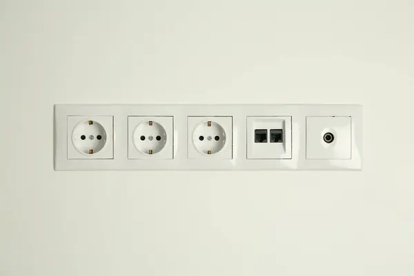 许多电源插座在室内白墙上装有以太网和电视同轴板 — 图库照片
