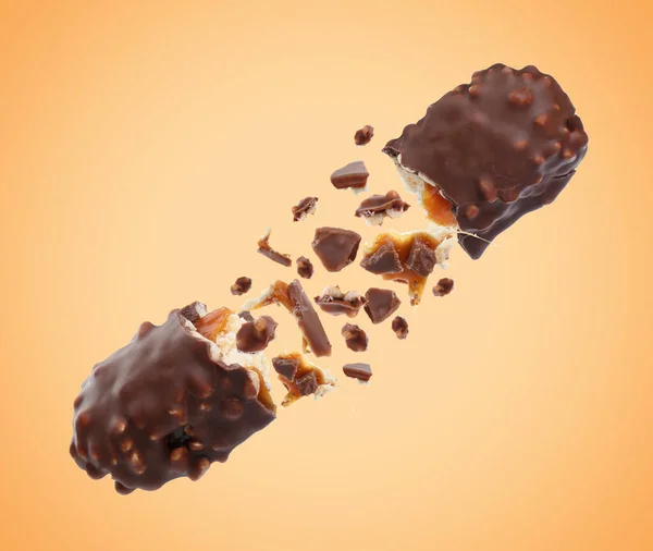 在淡橙色的背景下 与美味焦糖在空气中破碎的巧克力棒 — 图库照片