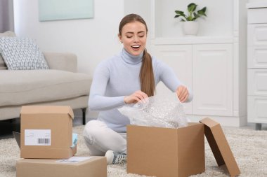 Duygusal kadın paketleri evde boşaltıyor. Çevrimiçi mağaza