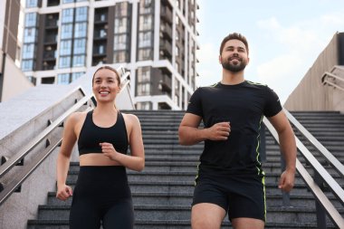 Sağlıklı bir yaşam tarzı. Açık havada koşan mutlu çift, alçak açılı manzara.