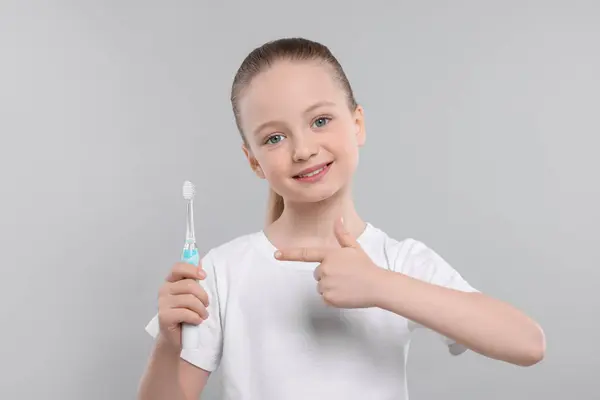 Щаслива Дівчина Тримає Електричну Зубну Щітку Світло Сірому Фоні — стокове фото