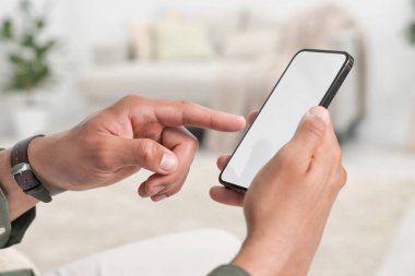 Modern cep telefonunu kapalı mekanda kullanan adam, yakın plan.